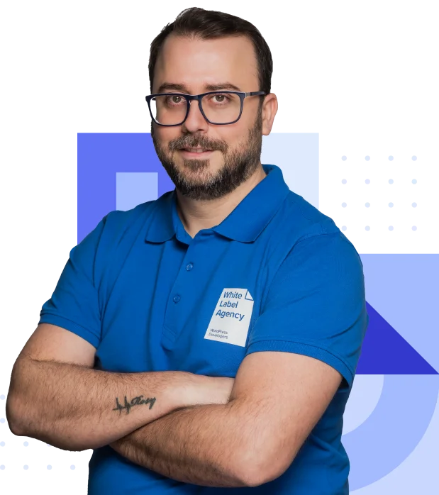Elie Ziadeh, Account Manager at White Label Agency, wearing a branded blue polo shirt, smiling with glasses and arms crossed.